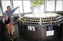  ??  ?? A foreign man puts his umbrella in an umbrella lock-up in Tokyo’s National
Art Center. (AFP)