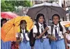  ??  ?? REVISED FORECAST: School students walk under umbrellas during monsoon rains in Kochi on Monday.