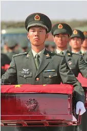  ??  ?? Caskets containing the remains of 117 Chinese soldiers killed in the 1950-53 Korean War are escorted by honour guards at the Taoxian internatio­nal airport in Shenyang, Liaoning Province, China.