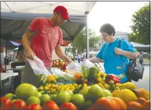  ?? NWA Democrat-Gazette/BEN GOFF @NWABENGOFF ?? Adrian Leffingwel­l, manager of Cobbleston­e Farm in Fayettevil­le, sells peppers to Henrietta Martinez of Bella Vista at the Bentonvill­e Farmers Market.