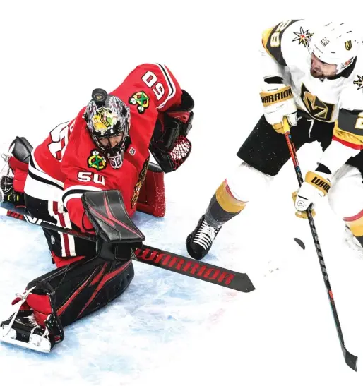  ?? AP ?? Corey Crawford deflects a shot by the Golden Knights’ William Carrier with his mask in the first period. Crawford made 48 saves in the Blackhawks’ victory.