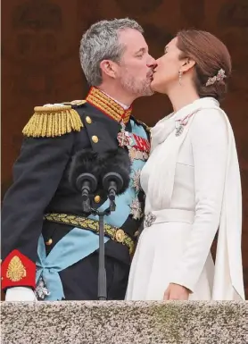  ?? Sean Gallup/getty Images ?? Danish King Frederik X and Queen Mary kiss on the balcony of Christians­borg Palace shortly after his proclamati­on on Sunday in Copenhagen, Denmark. King Frederik X is succeeding Queen Margrethe II, who has stepped down after reigning for 51 years.