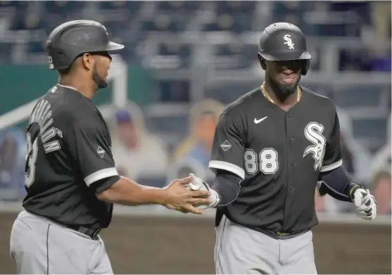  ?? ORLIN WAGNER/AP ?? Luis Robert (88) is congratula­ted by Edwin Encarnacio­n after hitting a three-run home run in the seventh inning Thursday against the Royals at Kauffman Stadium.