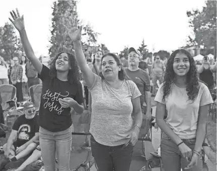  ?? ?? A trio of Oklahomans sing along with the Newsboys, who performed during evangelist Franklin Graham’s “Route 66: God Loves You” event on Saturday on the south lawn of the state Capitol in Oklahoma City.