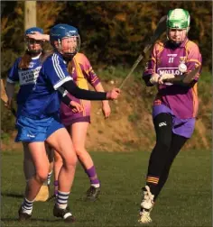  ??  ?? Ella Dalton of Wexford strikes as Jade Bergin (Laois) closes in.