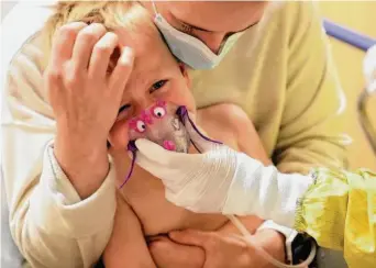  ?? Anthony Soufflé/Minneapoli­s Star Tribune ?? Meredith Legree of Lakeville, Minn., holds her son Andrew, 3, as he receives nebulizer treatment to help him to breathe while they await results of an RSV test at Children’s Hospital of St. Paul.