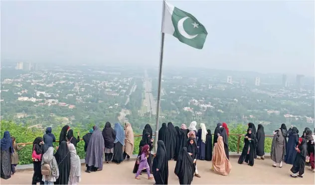  ?? Associated Press ?? ±
A Pakistani flag flutters at a park as women take a walk in Islamabad on Wednesday.