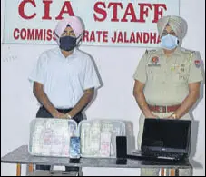  ?? HT PHOTO ?? Police officials with the cash seized from a Jalandhar-based cricket bookie.