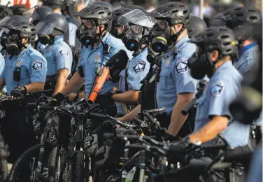  ?? Carlos Gonzalez / Minneapoli­s Star Tribune ?? Minneapoli­s police patrol a protest May 27. Many officers seeking disability cite posttrauma­tic stress.