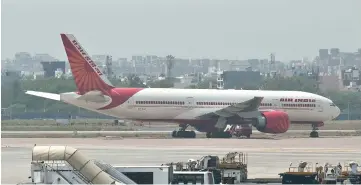  ??  ?? In this file photo an Air India plane is seen parked on the tarmac at the Indira Gandhi Internatio­nal Airport in New Delhi. The Indian government’s attempt to sell debt-laden national carrier Air India is in danger of hitting the skids as a key...