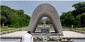  ?? — AP ?? A security guard pays respects in front of the cenotaph for the atomic bombing victims near Hiroshima Peace Memorial Museum in Hiroshima, western Japan.
