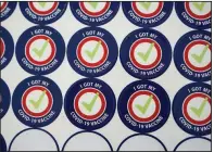  ?? (AP/Ted S. Warren) ?? Stickers await people getting their covid-19 vaccinatio­ns Tuesday at the Department of Veterans Affairs Puget Sound Health Care System campus in Seattle.