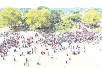  ??  ?? Aerial view showing migrants reaching Mexico after crossing the Suchiate River from Tecun Uman in Guatemala to Ciudad Hidalgo in Mexico, a day after a security fence on the internatio­nal bridge was reinforced to prevent them from passing through.