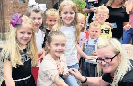  ??  ?? Tattoo You Eight-year-old Chloe McCallum gets a glitter tattoo from Libby Muirhead, of Glasgow Life