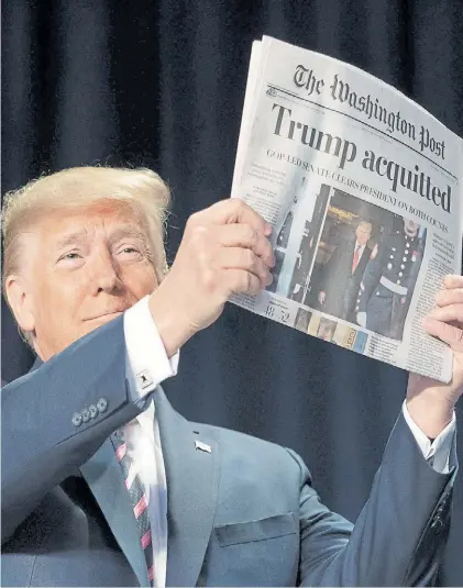  ?? DPA ?? Satisfacci­ón. Trump muestra el titular del Washington Post, con la absolución en el Senado.