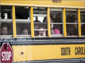  ?? THE ASSOCIATED PRESS ?? A Townville Elementary student looks out of the window of a school bus as she and her classmates are transporte­d to Oakdale Baptist Church, following a shooting at Townville Elementary in Townville on Wednesday.