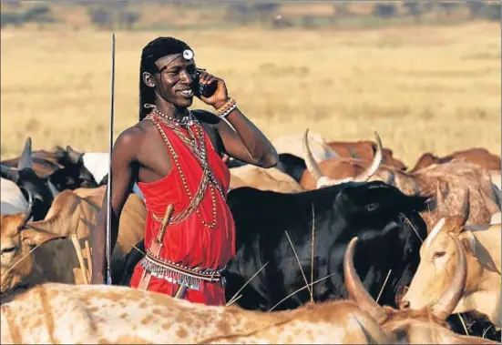  ?? JOSEPH VAN OS / GETTY ?? Dos mons. Un massai parla pel mòbil mentre vigila el bestiar a la saba- na. Kènia és un dels països africans on el mòbil s’ha implantat més