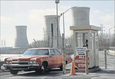  ??  ?? A car passes through a security gate outside the Three Mile Island nuclear power station near Harrisburg, Pennsylvan­ia, shortly before the meltdown in 1979