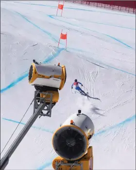  ?? (AP/Luca Bruno) ?? Alexis Pinturault of France skis past snowmaking machines Feb. 3 during a men’s downhill training run at the 2022 Winter Olympics in the Yanqing district of Beijing.