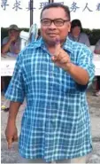  ??  ?? Local voter Mohamed Saleman, 57, from Kampung Baharu shows his left index finger, marked with the indelible ink.