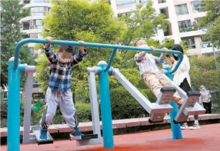  ?? ?? Two boys play in a residentia­l compound in Shanghai’s Putuo District yesterday. — Xinhua