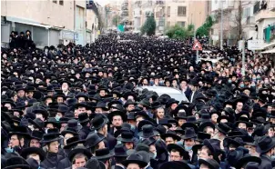  ?? — AFP ?? Thousands of Ultra-Orthodox Jews attend a funeral procession for the Head of the Brisk Yeshiva, Rabbi Meshulam Dovid Soloveitch­ik in Jerusalem on Sunday, following his passing aged 99 due to months-long illness compounded by the Coronaviru­s.