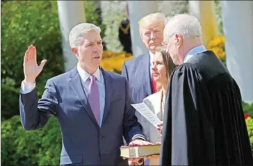  ?? MANDEL NGAN/AFP ?? US President Donald Trump (centre) watches as Justice Anthony Kennedy (right) administer­s the oath of office to Neil Gorsuch (left) as an associate justice of the US Supreme Court in the Rose Garden of the White House on Monday in Washington.