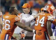  ?? BOB LEVERONE — THE ASSOCIATED PRESS FILE ?? Clemson head coach Dabo Swinney, center, congratula­tes his players during the second half of the Atlantic Coast Conference championsh­ip game last December against Miami. The Tigers are pursuing their fourth straight Atlantic Coast Conference...
