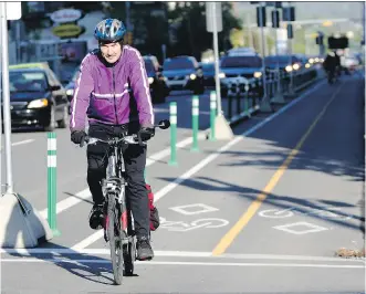  ?? LEAH HENNEL/ CALGARY HERALD ?? Bill Cozens uses Calgary’s new cycle tracks recently during his morning commute. Calgary is at the top of most quality of urban living lists, Richard White says.