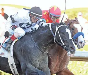  ?? COADY PHOTOGRAPH­Y ?? Long Range Toddy and jockey Jon Court, left, pass Improbable and jockey Drayden Van Dyke in the final strides to win a division of March’s Rebel Stakes at Oaklawn Park in Hot Springs, Arkansas.