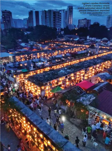  ?? ALDO NELBERT BANAYNAL ?? Lighted candles illuminate
Carreta Cemetery where police estimated about 55,000 people visited their departed
loved ones yesterday.