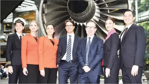  ?? PETER PARKS/AFP ?? Qantas chief executive officer Alan Joyce (centre-right) and chief financial officer Tino La Spina (centre-left) are photograph­ed with Qantas aircrew next to a model plane engine at their headquarte­rs after announcing the airline’s annual results in...