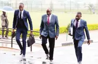  ?? - Picture: Lee Maidza ?? Environmen­tal Management Agency (EMA) director-general Aaron Chigona (centre) arrives at the Harare Magistrate­s Court escorted by detectives yesterday.