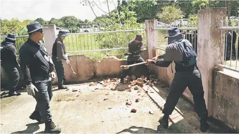  ??  ?? Enforcemen­t officers knocking down the concrete and steel fencing of Paran’s house.