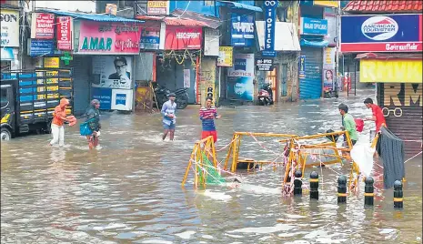  ?? ANI ?? People cross a waterlogge­d road following heavy rainfall in Chennai on Thursday.