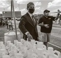  ??  ?? Mayor Ron Nirenberg helps hand out sanitizer last week to small-business owners. He has risen to the moment, but he is also looking beyond it for the city.