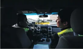  ??  ?? Sazzad Hossain, left, and Jimmy Jeong drive around Olds, Alta., as part of a citizens’ patrol that keeps an eye out for signs of crime or suspicious activities.