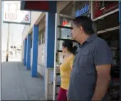  ?? BEA AHBECK/NEWS-SENTINEL ?? Owners of Tokay Liquors, Satnam and Gary Parmar, look on as Lockeford Street is paved by workers with George Reed Inc. in Lodi on Sept. 4, 2019.