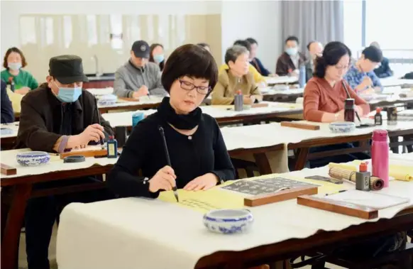  ?? ?? April 12, 2021: Offline calligraph­y classes resume at a community college for seniors in Fuzhou City, southeaste­rn China’s Fujian Province, as the epidemic situation has stabilized in the country. IC