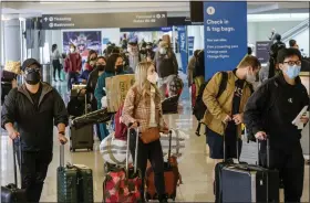  ?? RINGO H.W. CHIU — THE ASSOCIATED PRESS ?? Holiday travelers wearing face masks line to check in at the Los Angeles Internatio­nal Airport in Los Angeles, Wednesday.