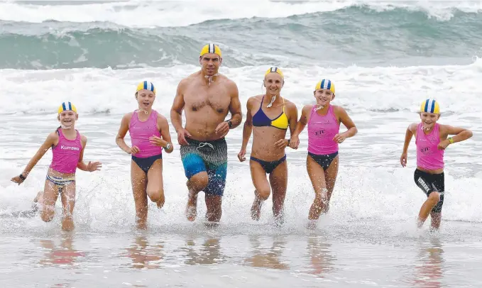  ?? Picture: MIKE BATTERHAM ?? The Raywards (from left) Elke. 7, Jasmine, 11, dad Ben, 41, mum Cathryn, 39, Bianca, 9, and Dane, 8, emerge from the surf at Kurrawa beach.
