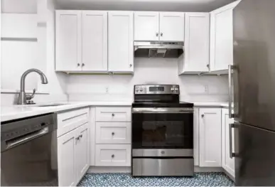  ?? ?? LEFT The kitchen features white cabinets and stainless steel appliances.