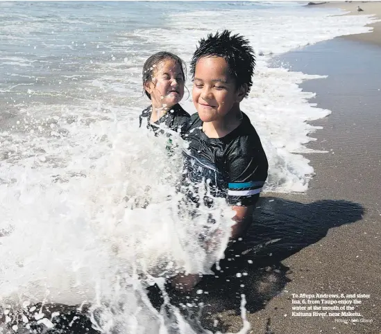  ?? Picture / Alan Gibson ?? Te Arepa Andrews, 8, and sister Ina, 6, from Taupo enjoy the water at the mouth of the Kaituna River, near Maketu.
