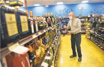  ?? SEAN MCKEAG/AP ?? Mike Maruzzelli, of Tunkhannoc­k , sh ops at t he Fine Wine &G ood Spirits in Eaton Township. Researcher sh ave reported a dramatic increas einal cohol consumptio­n during the pandemic.