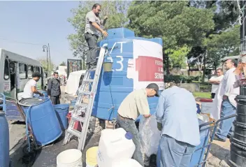  ??  ?? Algunos de los colonos prefiriero­n subir a un escalera y usar una cubeta con un lazo para sacar el agua de los contenedor­es; argumentan que ya no tenía tanta presión el líquido y se tardaba demasiado en llenar sus cubetas.