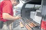  ?? PHOTO BY LIPO CHING — STAFF PHOTOGRAPH­ER ?? San Mateo County Sheriff’s Sgt. Pronske checks the seven rifles and shotguns turned in by Jim Fortes, 60, of Redwood City, on Saturday.