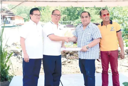  ?? SUNSTAR / ALLAN DEFENSOR ?? OFF TO A GOOD START. SWU-Phinma president Chito Salazar and engineer Richard Siton hand over the project plans to barangay officials Lemar Alcover of Sambag 1 and Carl Stephen Belarmino of Sambag 2.