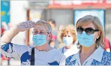  ?? Picture: REUTERS/Sergio Perez ?? A woman wearing a protective face mask salutes as people hold a minute of silence during the last day of the official 10-day mourning of those who died of the coronaviru­s disease, at Puerta del Sol square in Madrid, Spain on Friday.