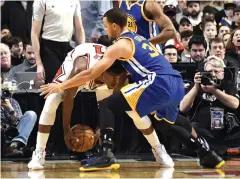 ??  ?? Warriors guard Stephen Curry, right, defends Bulls forward Jimmy Butler during the second half.
