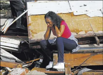  ?? ROGELIO V. SOLIS/THE ASSOCIATED PRESS ?? Shanise McMorris grieves Saturday on the slab of her Hattiesbur­g, Miss., home after a tornado hit the city. The tornado was part of a wall of stormy weather traveling across the region, bringing with it rain and unstable conditions.